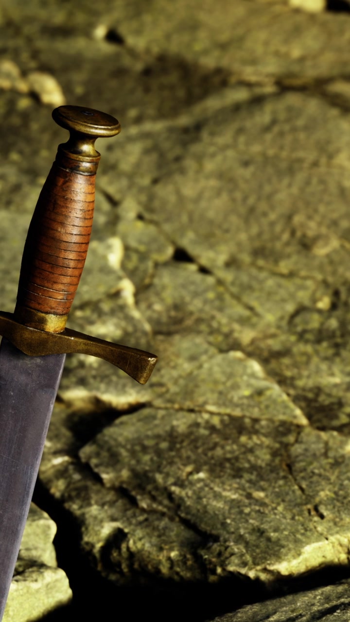 Espada repousa sobre superfície de pedra em ambiente externo com luz natural.