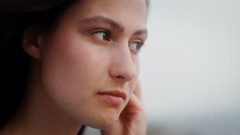 woman with earbuds looking thoughtful