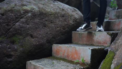 man's feet descending cliff steps