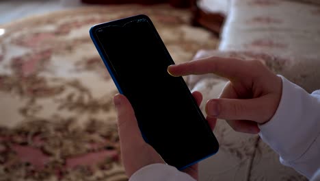 a teenager looks at information on a smartphone. alpha channel included. you can insert your video into the smartphone screen.