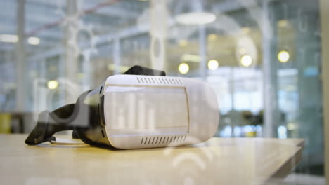 multiple digital icons against vr headset on a table at office