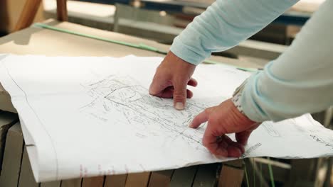 project manager pointing at the blueprints of a construction project of a luxury home