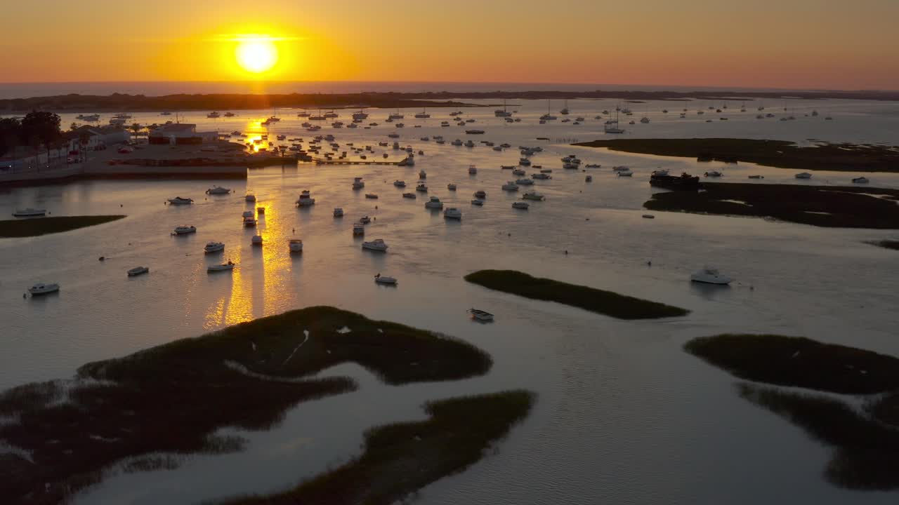Sunset over a tranquil harbor with many boats