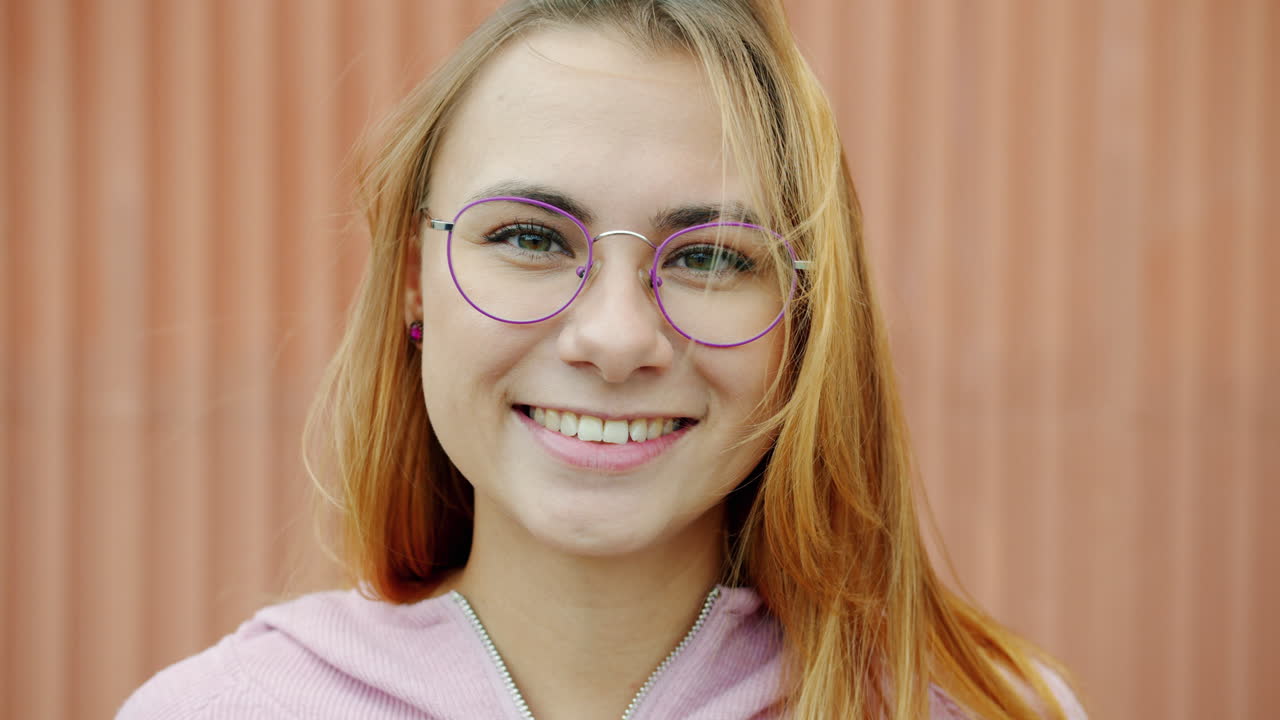 Woman wearing glasses smiling at the camera