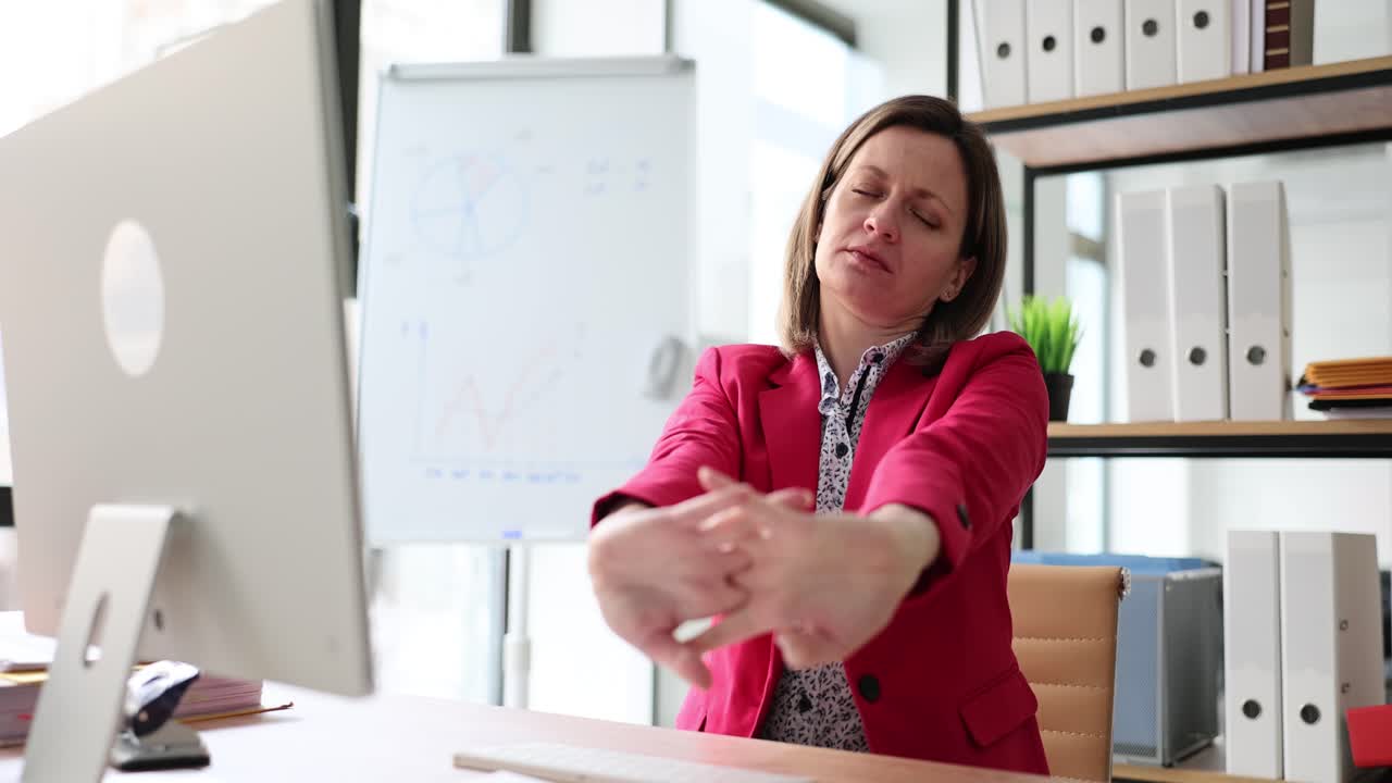 Businesswoman stretching arms to relieve fatigue at office desk