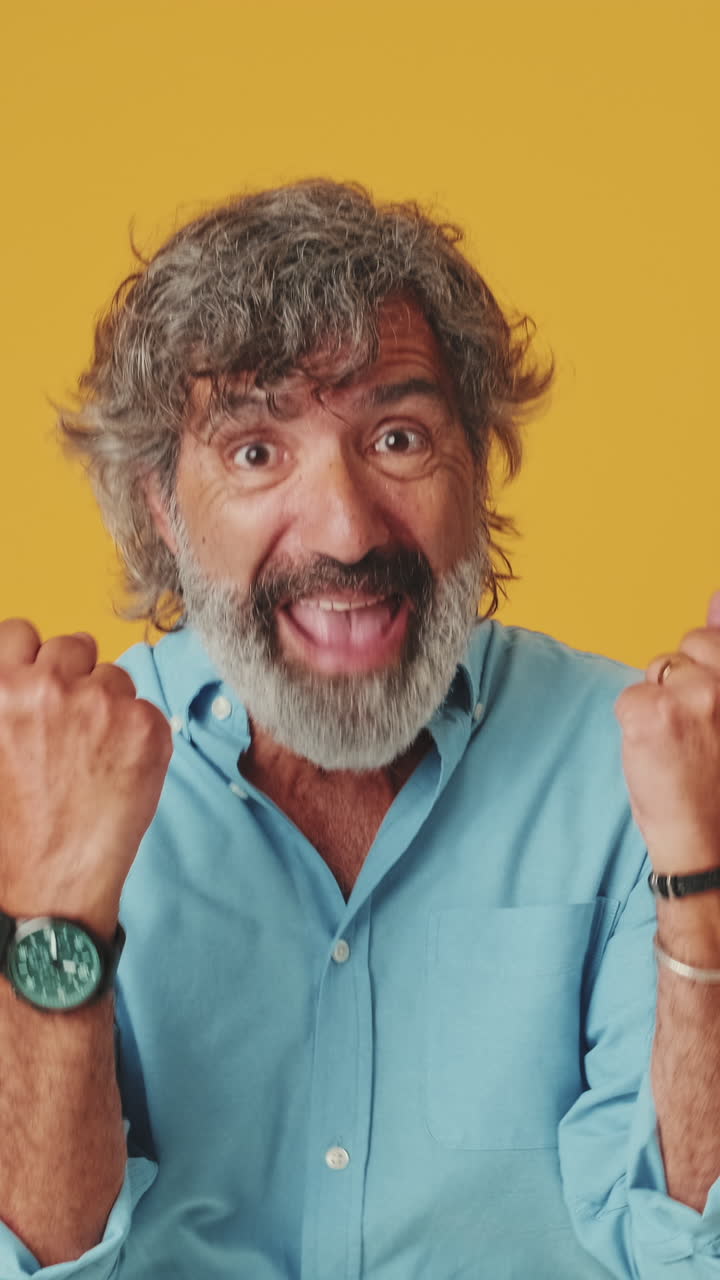 Uomo maturo che reagisce con sorpresa e festeggia con gioia