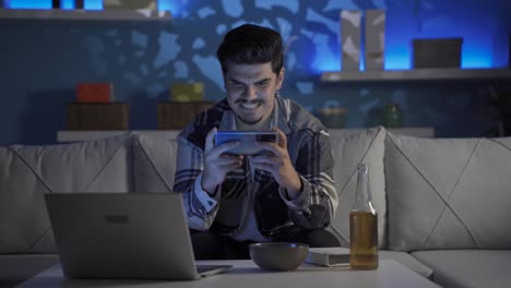 joven jugando por teléfono por la noche, borracho.
