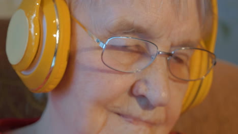 mujer anciana con auriculares inalámbricos