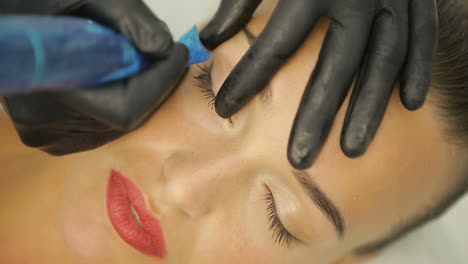 beautician making artificial lashes. cosmetologist making eyeliner permanent make up