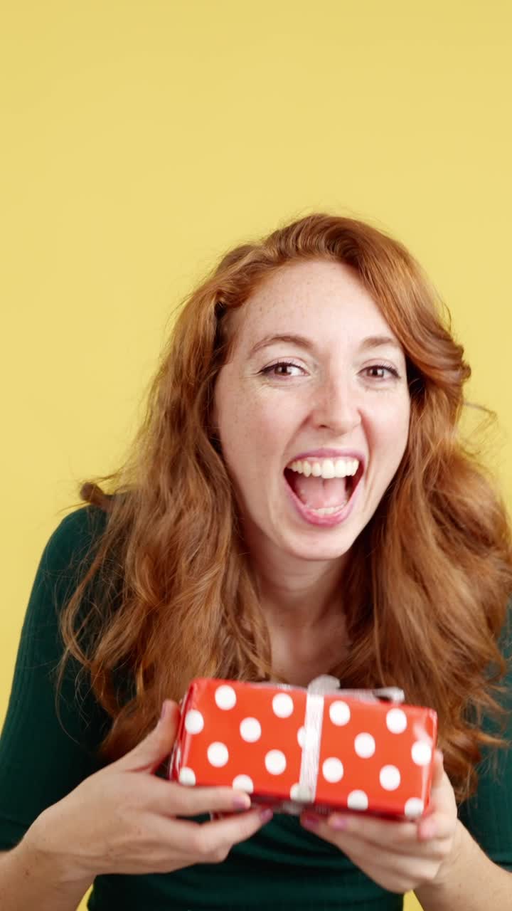 Smiling Red-Haired Woman Posing and Holding a Gift