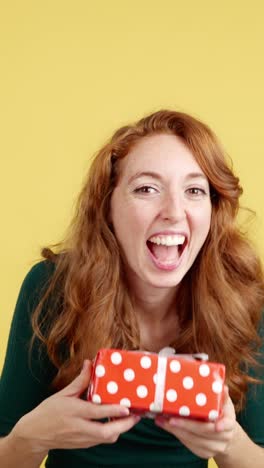 smiling red-haired woman posing and holding a gift
