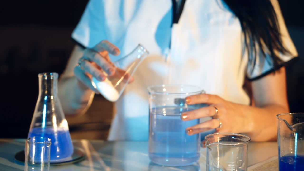 Young woman working in laboratory on experiments. Testing chemicals in laboratory