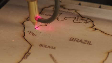 la máquina de corte por láser cnc corta el mapa del mundo en tabla de madera y contrachapado