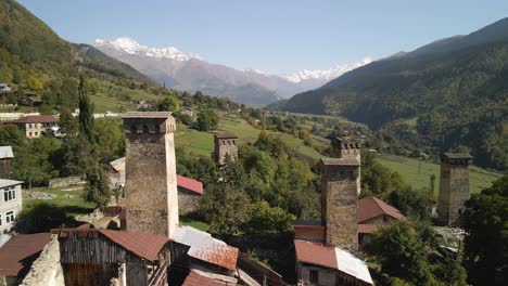 drone view of residential and caucasus mountain in background, svaneti, georgia