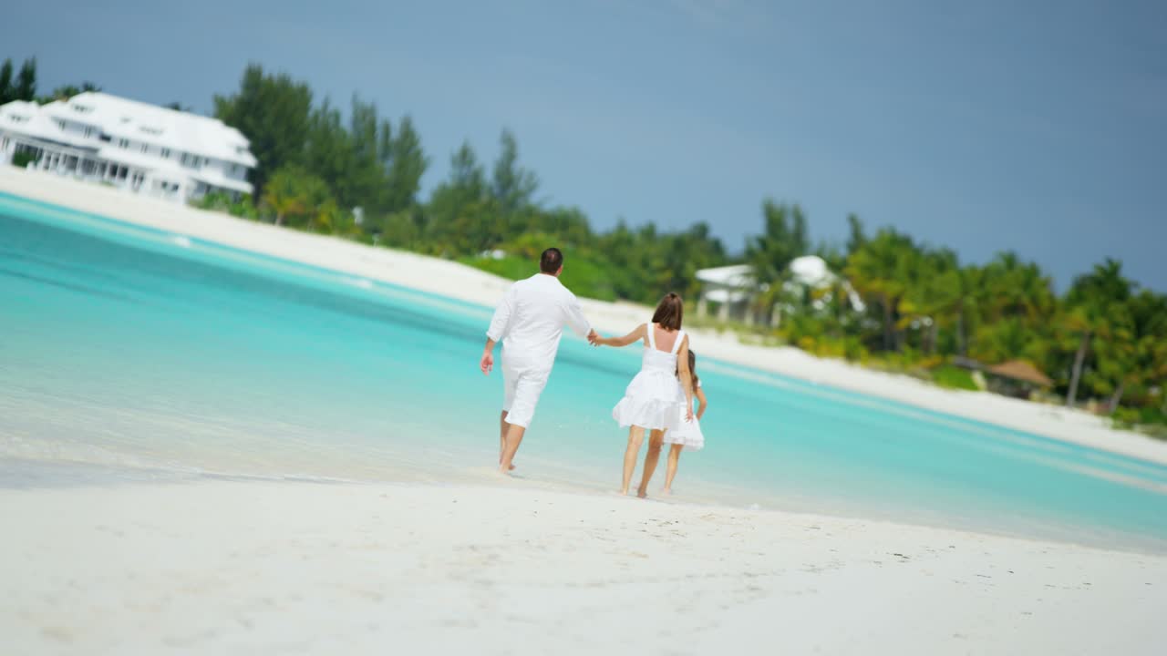 Kaukasische ouders met hun dochter op een tropisch strand