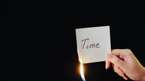 man burns a paper with the inscription time