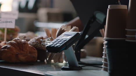 close up customer paying using credit card contactless payment in cafe spending money with wireless transaction in restaurant coffee shop