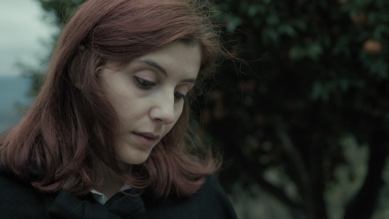 молодая итальянка читает таинственную книгу в горах среди деревьев.