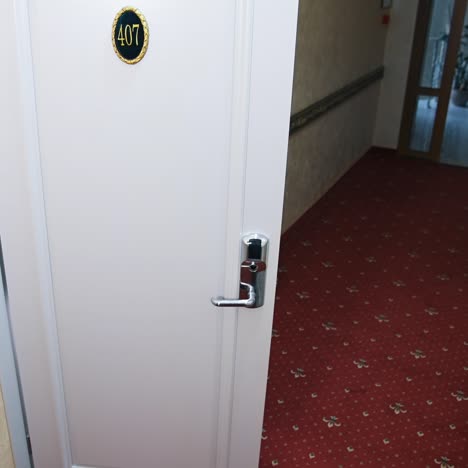cute happy woman with suitcase enters a room of a hotel. cheerful young girl ready to have happy holidays away from home