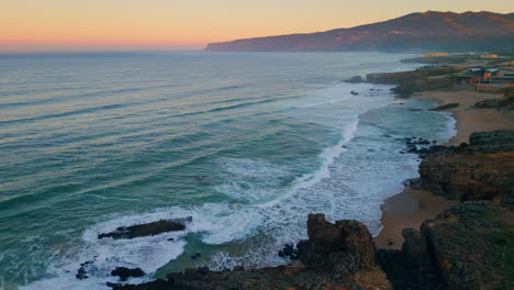 dramatic pink sunrise beach in super slow motion. aerial view ocean foamy waves