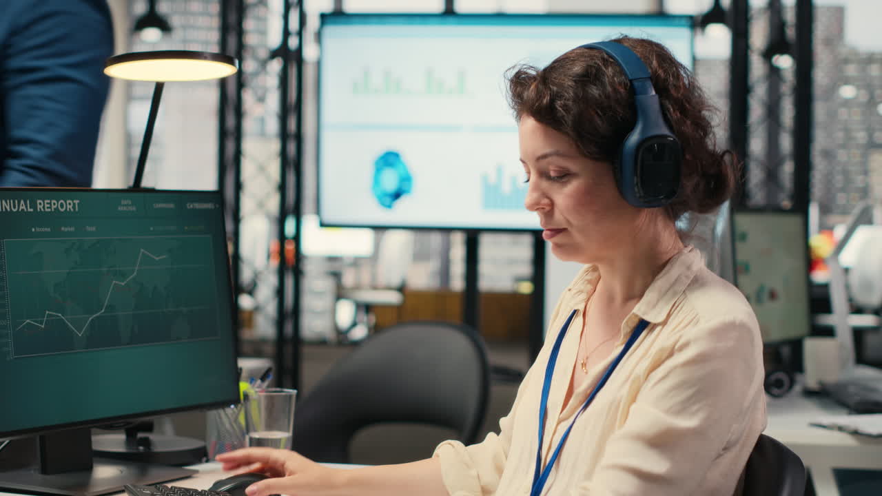 Vertical Video Female executive consultant listening to songs on headphones at the workstation
