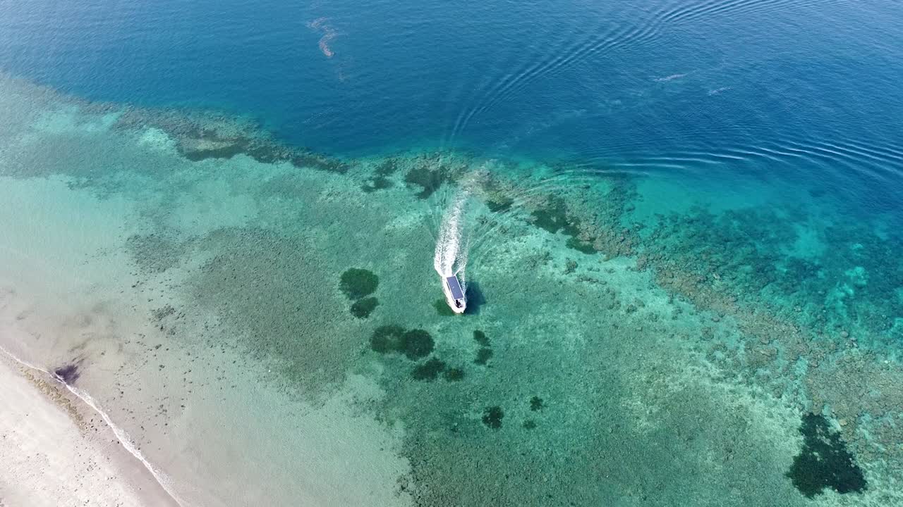 barco de buceo moviéndose sobre un hermoso océano turquesa cristalino con un impresionante arrecife de coral en timor leste, sudeste de asia
