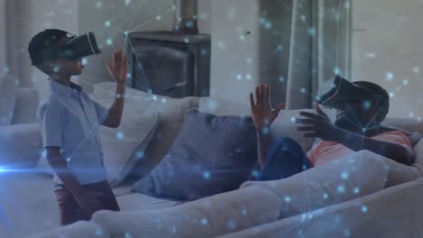 animation of constellations over happy african american father and son wearing vr headsets