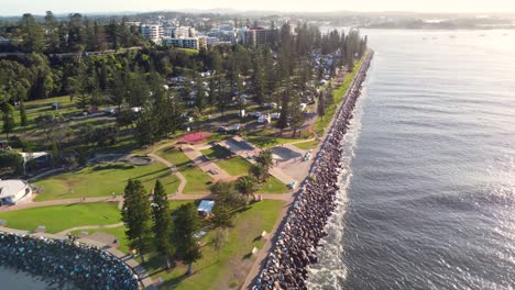 Drone-aerial-landscape-pan-shot-of-Port-Macquarie-skatepark-and-break-wall-pine-tops-beach-Hastings-River-inlet-travel-tourism-NSW-Australia-4K