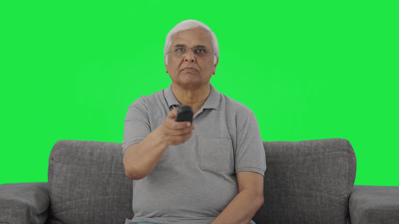 Indisk ældre mand ser tv på greenscreen