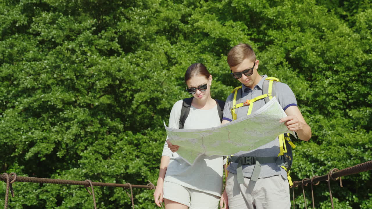 un hombre y una mujer están estudiando el mapa que se encuentran en el puente en el fondo de un pintoresco s