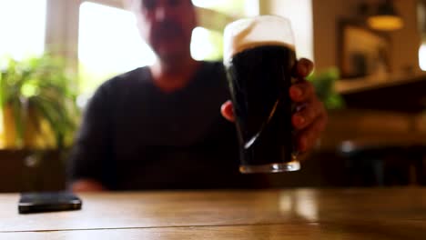 man drinking stout in a cozy pub