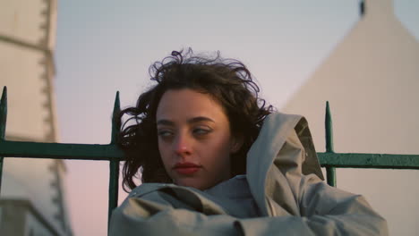 closeup bored girl waiting lean on fence. calm pretty teenager dreaming at night