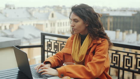 Frau-Arbeitet-Am-Laptop-Auf-Der-Dachterrasse