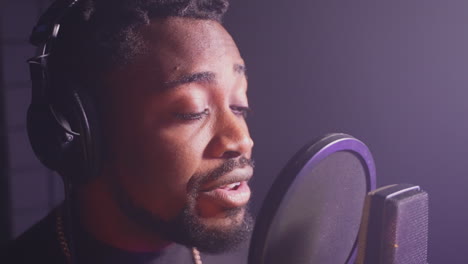 man singing into a microphone in a recording studio