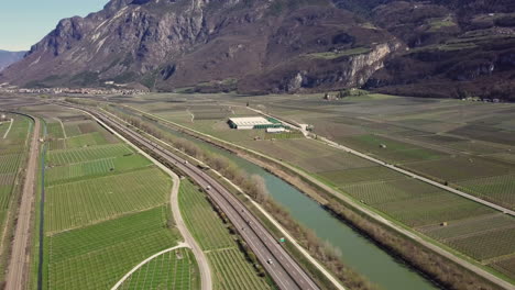 Aerial-clip-of-some-vines-camp-in-the-Alps-area,-with-a-farm-and-a-road-in-the-frame