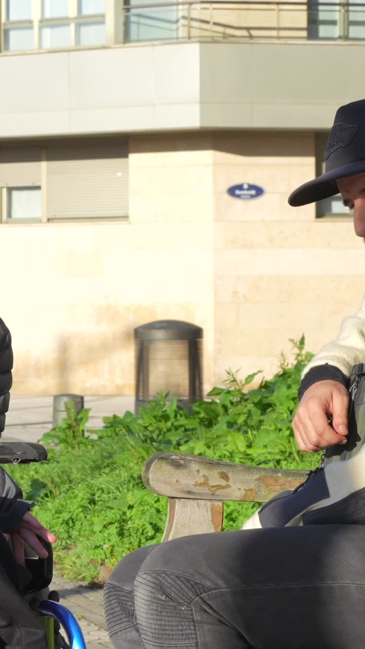 Man in wheelchair talking to someone outdoors