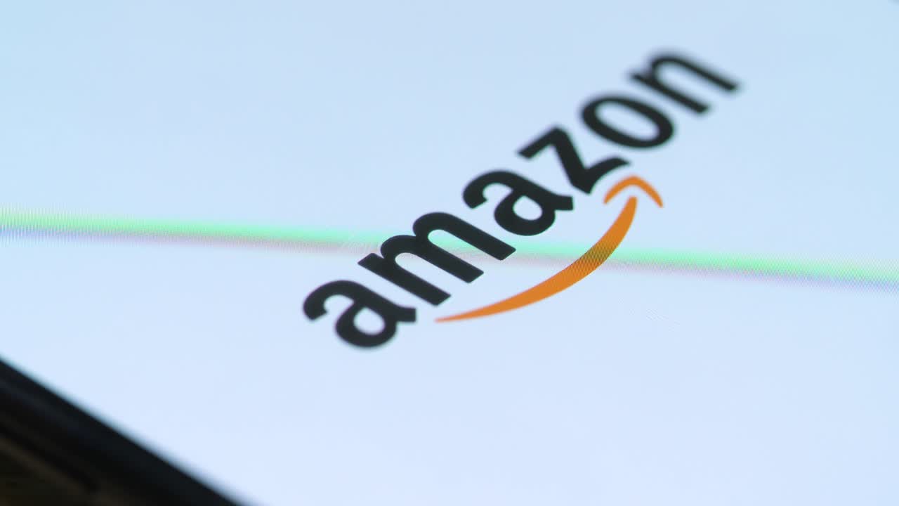 매크로 손가락이 스마트 폰에서 아마존 쇼핑 아이콘을 만질 때