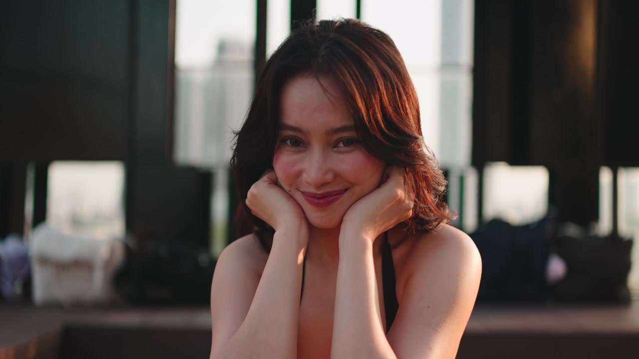 微笑的年輕女子坐在天台墊子上