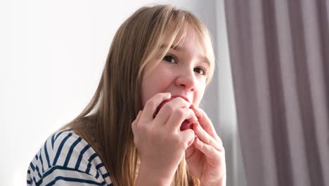 child girl blonde eats an apple on a white background child girl blonde eats an apple on a white background video delicious ripe autumn fruits vegetarianism in children
