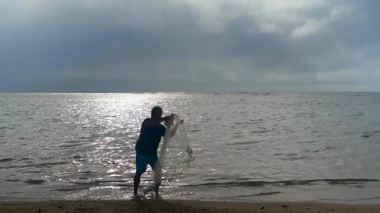 해변에서  ⁇ 시망을 들고 있는 어부 4k