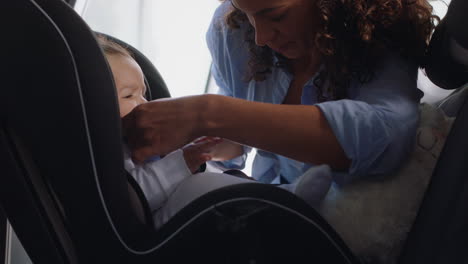 Madre-Joven-Poniendo-Al-Bebé-En-El-Asiento-Del-Automóvil-Asegurando-Al-Niño-Para-El-Viaje-Por-Carretera-Padre-Responsable-Que-Cuida-A-Los-Niños-Pequeños-La-Seguridad-En-El-Vehículo