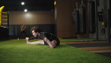 male boxer making stretching in sport club