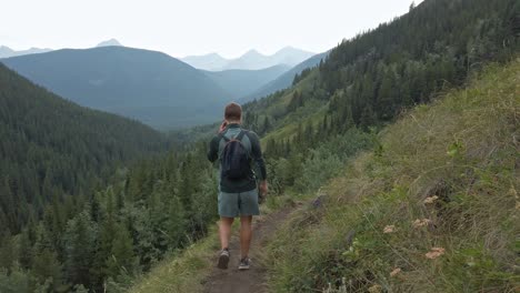 hiker walking downhill on a trail in high altitude rockies kananaskis alberta canada