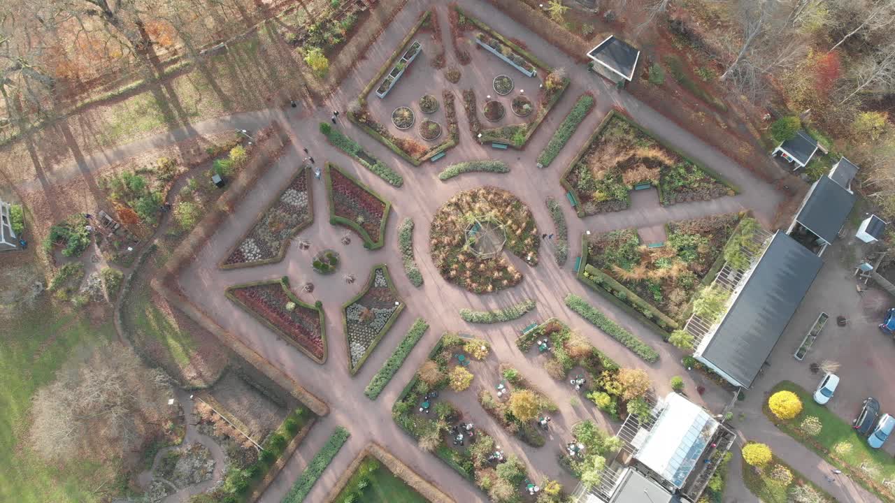 Ovenfra-luftfoto af en symmetrisk botanisk engelsk have på en efterårsdag.