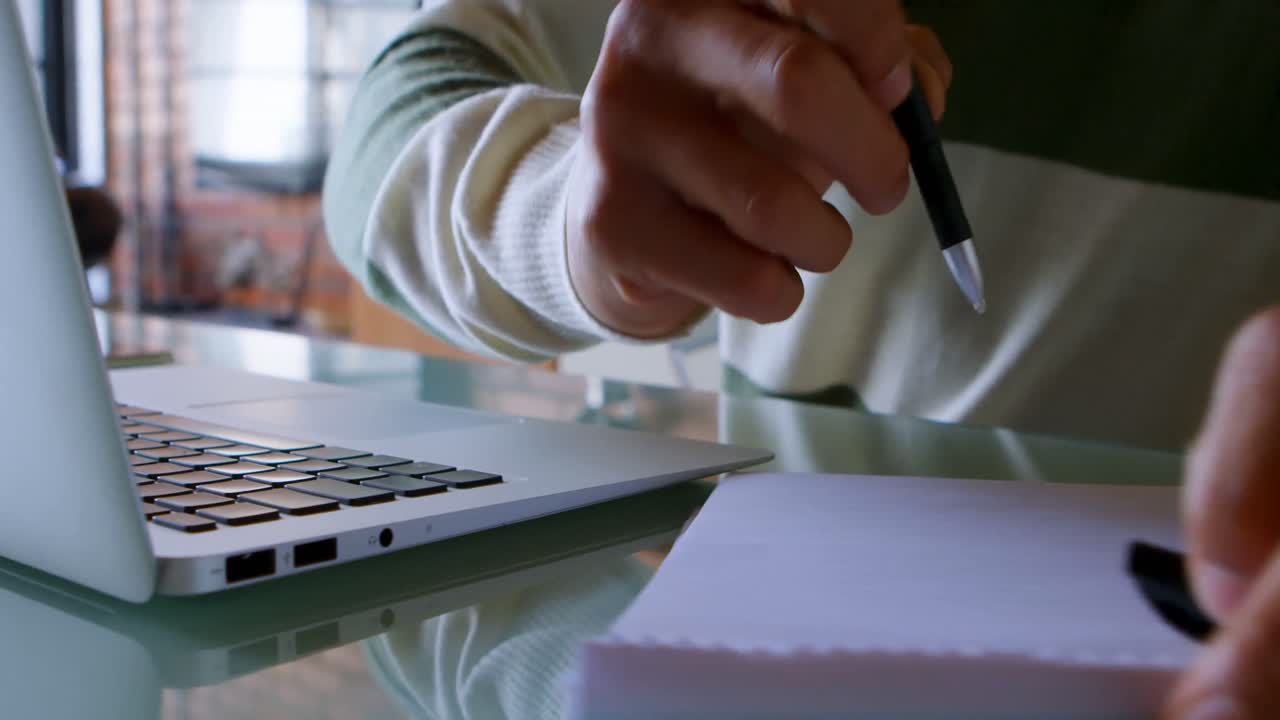 Man writing on notepad on table at home 4k