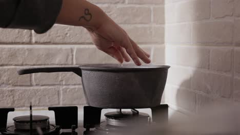 Female-Hand-Pouring-Salt-In-Cooking-Pan---Close-Up