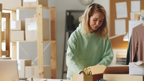 mujer empacando pedidos en una oficina de una pequeña empresa