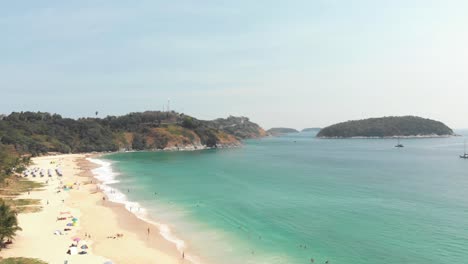 reveal of tranquil nai harn bay in southern phuket, thailand - aerial wide fly-over shot