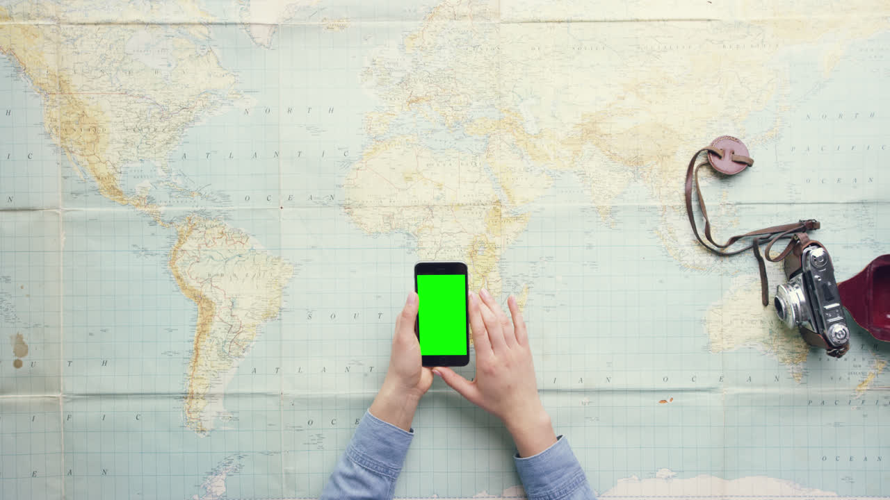 vista superior mujer viajera manos planeando vacaciones usando una aplicación de teléfono móvil escritorio vintage desde arriba - dragón épico rojo