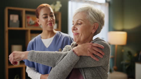 senior woman doing stretching exercises with caregiver
